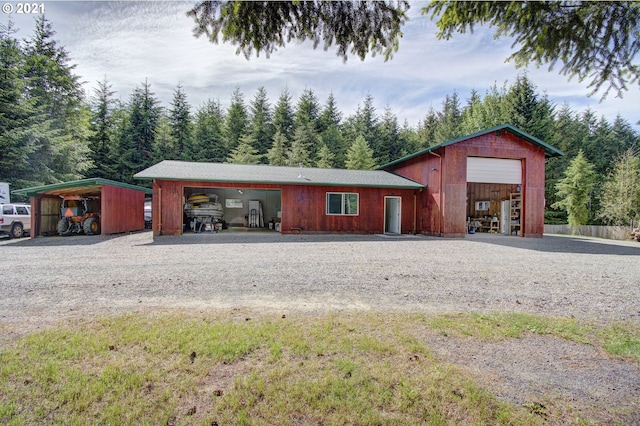 view of outdoor structure with an outbuilding, a carport, and driveway