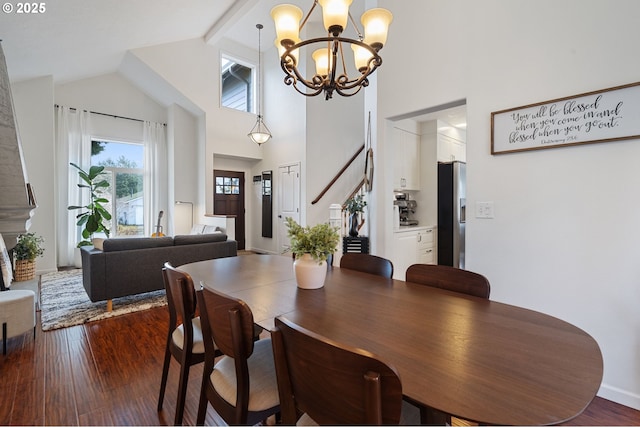 dining room with beamed ceiling, wood-type flooring, a notable chandelier, and high vaulted ceiling