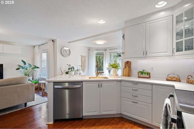 kitchen with dark hardwood / wood-style flooring, sink, stainless steel dishwasher, and white cabinets