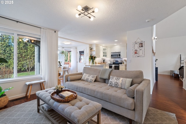 living room featuring dark hardwood / wood-style flooring, plenty of natural light, and a textured ceiling