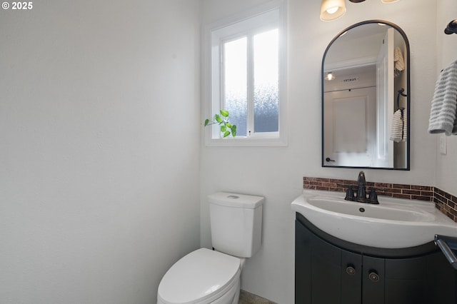 bathroom with vanity, decorative backsplash, and toilet