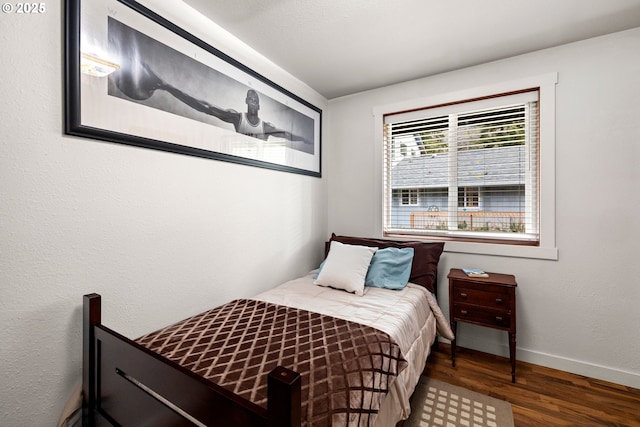 bedroom with baseboards and wood finished floors