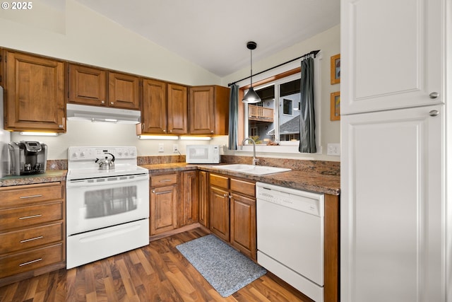 kitchen with under cabinet range hood, white appliances, a sink, vaulted ceiling, and brown cabinets