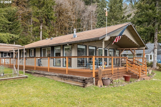 back of property featuring a deck and a lawn