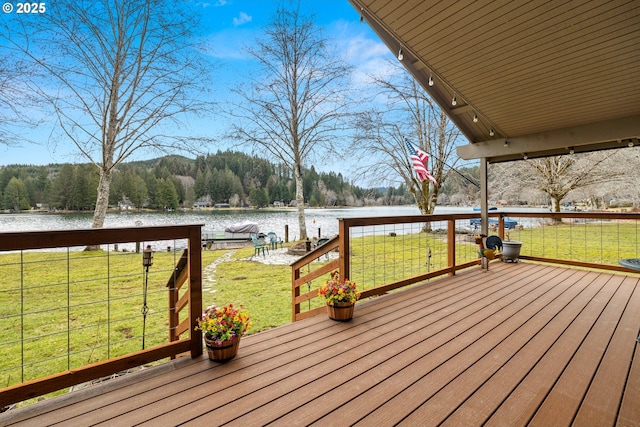 wooden terrace featuring a yard and a water view