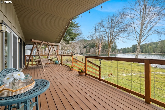 deck with a lawn and a water view