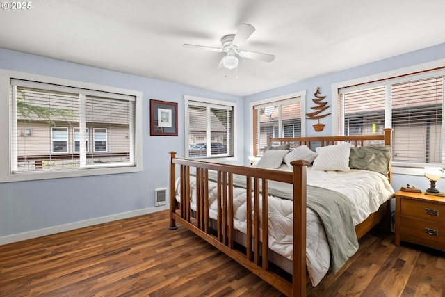 bedroom featuring visible vents, dark wood finished floors, baseboards, and multiple windows