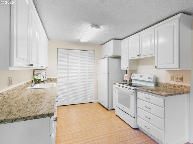 7116 SW Murray Blvd, Beaverton, OR 97008 - kitchen featuring white appliances, white cabinetry, light wood-type flooring, and a textured ceiling