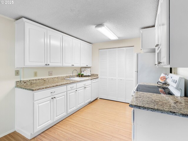 7116 SW Murray Blvd, Beaverton, OR 97008 - kitchen with a sink, light wood-style flooring, white appliances, white cabinetry, and a textured ceiling