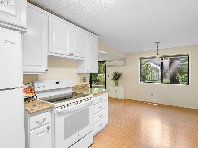 7116 SW Murray Blvd, Beaverton, OR 97008 - kitchen with white appliances, a wall mounted air conditioner, white cabinets, hanging light fixtures, and baseboards
