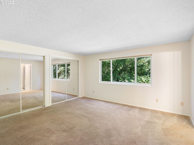 7116 SW Murray Blvd, Beaverton, OR 97008 - unfurnished bedroom featuring two closets, a textured ceiling, carpet flooring, and baseboards
