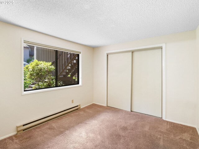 7116 SW Murray Blvd, Beaverton, OR 97008 - unfurnished bedroom featuring a baseboard heating unit, carpet, a textured ceiling, and a closet
