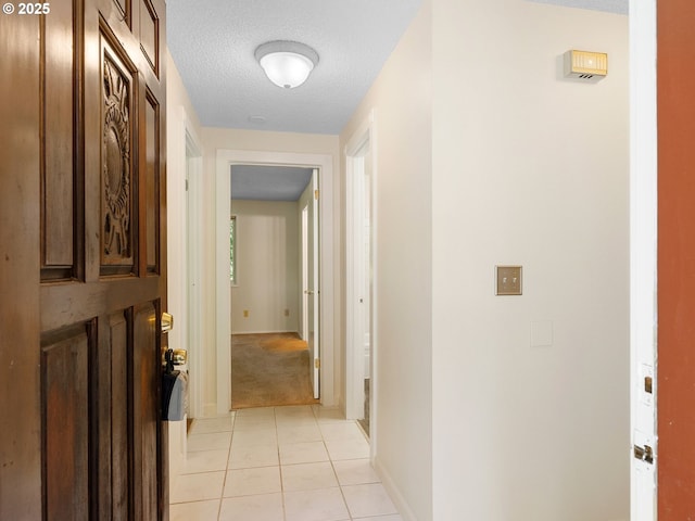 7116 SW Murray Blvd, Beaverton, OR 97008 - hallway featuring a textured ceiling, light tile patterned floors, and baseboards