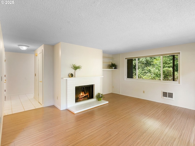 7116 SW Murray Blvd, Beaverton, OR 97008 - unfurnished living room with wood finished floors, a fireplace, and a textured ceiling