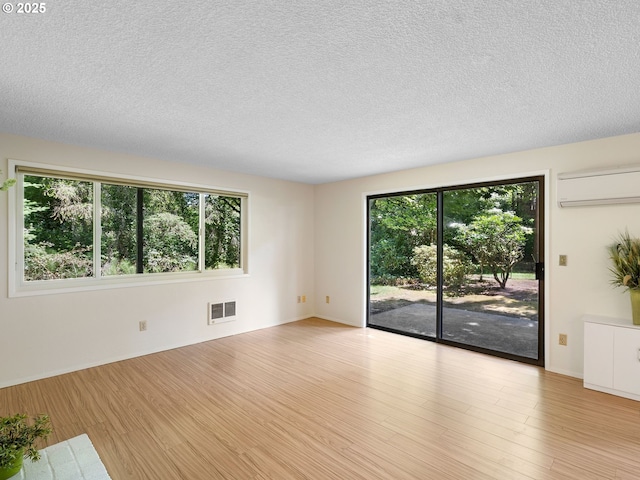 7116 SW Murray Blvd, Beaverton, OR 97008 - spare room featuring an AC wall unit, wood finished floors, a textured ceiling, and baseboards