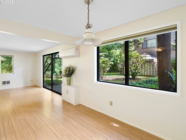 7116 SW Murray Blvd, Beaverton, OR 97008 - empty room featuring an AC wall unit, wood finished floors, and plenty of natural light