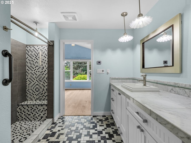 343 Hemlock St, Seaside, OR 97138 - bathroom featuring baseboards, visible vents, tiled shower, tile patterned floors, and vanity