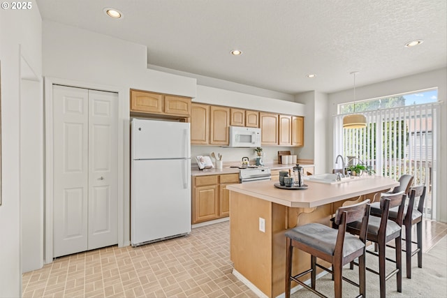 2539 NW 167th Ave, Beaverton, OR 97006 - kitchen featuring white appliances, a sink, light countertops, an island with sink, and a kitchen bar