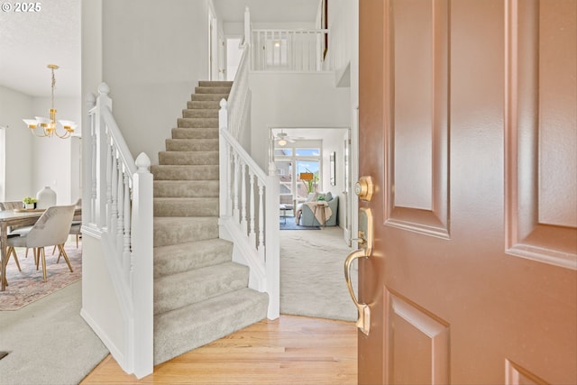 2539 NW 167th Ave, Beaverton, OR 97006 - entrance foyer with stairs, a chandelier, light wood-style floors, and a high ceiling
