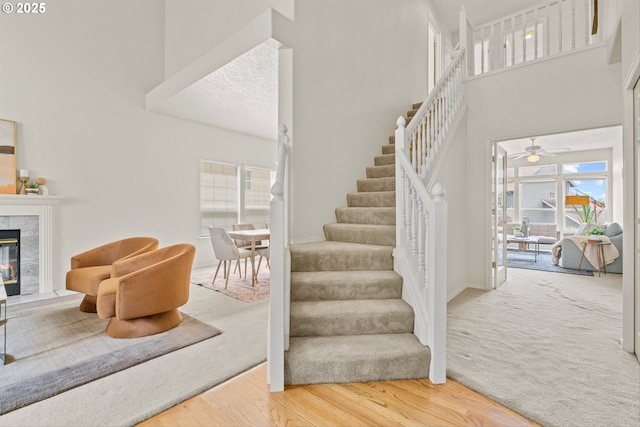 2539 NW 167th Ave, Beaverton, OR 97006 - stairs featuring a high ceiling, ceiling fan, wood finished floors, and a tiled fireplace