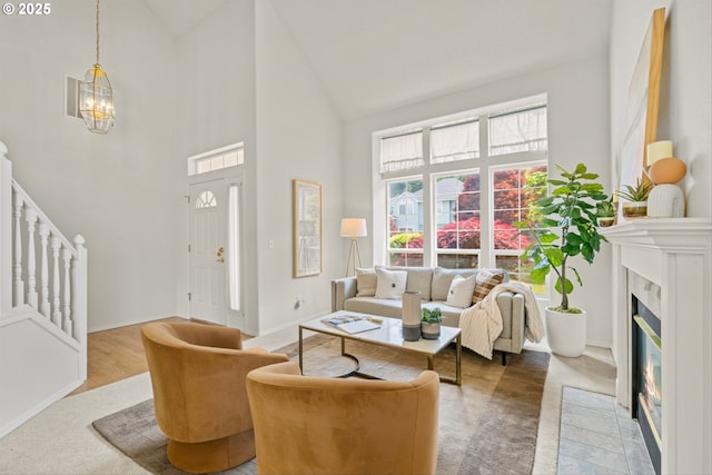 2539 NW 167th Ave, Beaverton, OR 97006 - living area with high vaulted ceiling, a chandelier, stairway, baseboards, and a fireplace with flush hearth