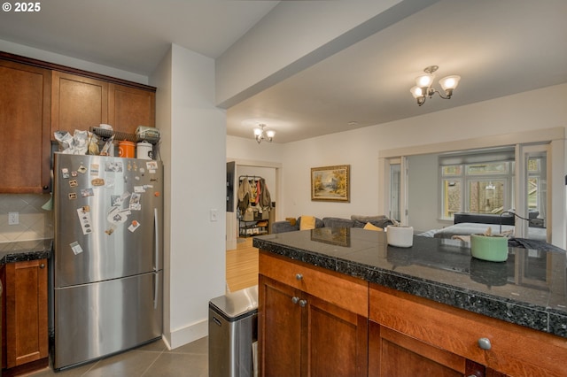 kitchen with tile counters, tasteful backsplash, open floor plan, and freestanding refrigerator
