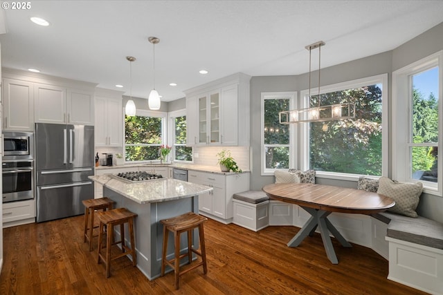 kitchen featuring stainless steel appliances, breakfast area, white cabinetry, glass insert cabinets, and recessed lighting