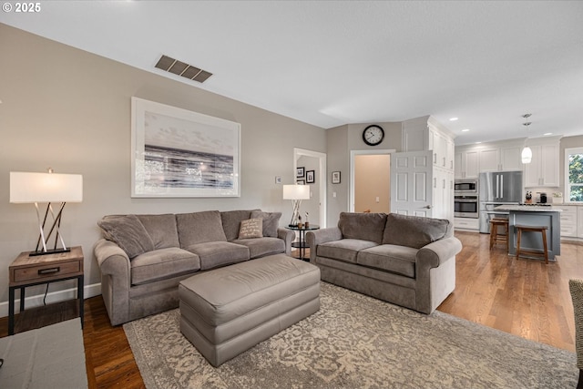 living room featuring light wood-type flooring, recessed lighting, and baseboards