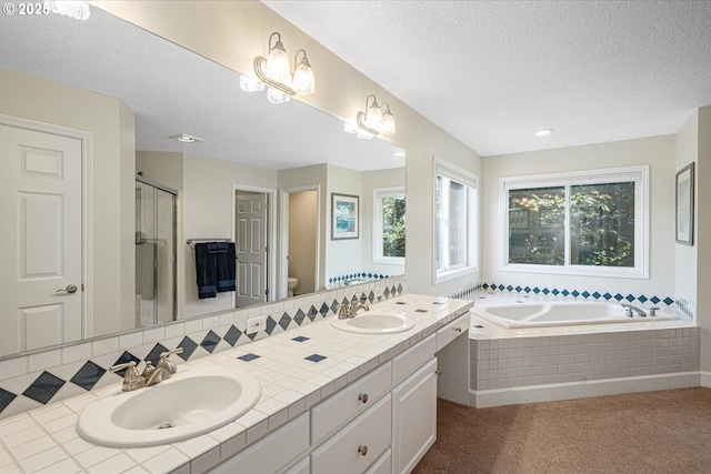 bathroom with a shower stall, a bath, a textured ceiling, toilet, and double vanity