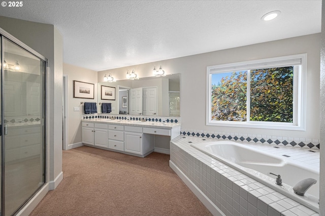 full bathroom featuring a shower stall, a bath, vanity, a textured ceiling, and baseboards