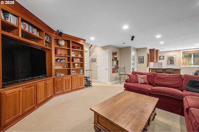 living area with light carpet, recessed lighting, and baseboards