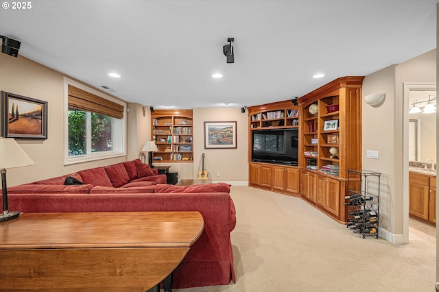 living area featuring light colored carpet, recessed lighting, baseboards, and built in shelves