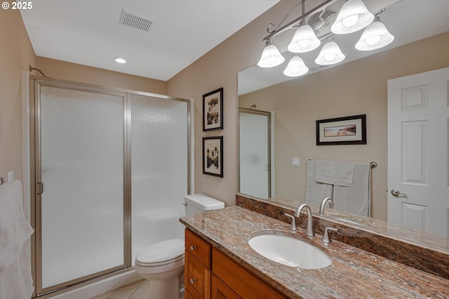 bathroom featuring toilet, a stall shower, vanity, and tile patterned flooring