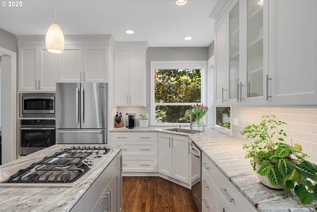 kitchen with appliances with stainless steel finishes, a sink, white cabinets, and recessed lighting