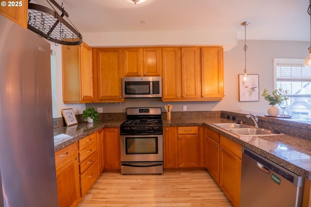 9235 NW Germantown Rd, Portland, OR 97231 - kitchen featuring appliances with stainless steel finishes, light wood-style floors, a peninsula, and dark countertops