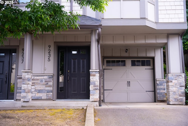 9235 NW Germantown Rd, Portland, OR 97231 - entrance to property featuring stone siding, board and batten siding, a garage, and driveway