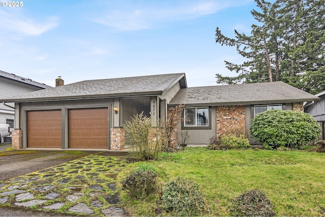 view of front of property featuring an attached garage, driveway, a front lawn, and roof with shingles