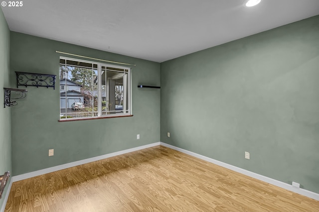 spare room featuring baseboards, wood finished floors, and recessed lighting