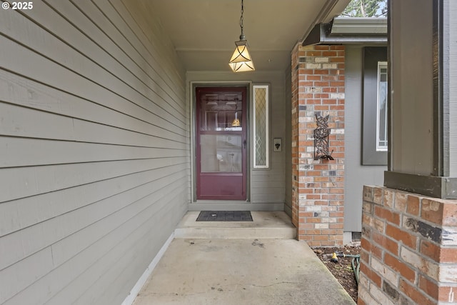 view of exterior entry with brick siding