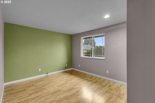 spare room with recessed lighting, baseboards, and wood finished floors