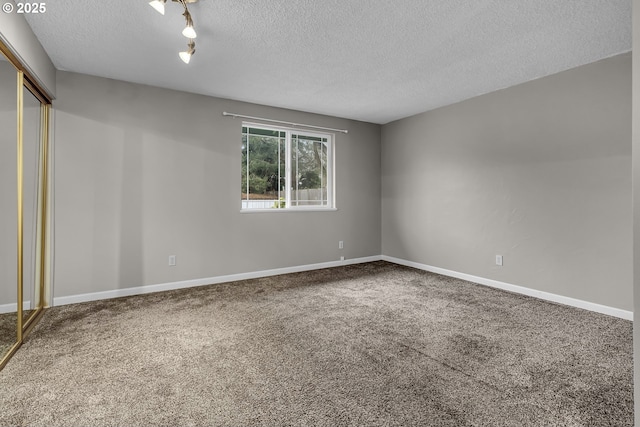 unfurnished bedroom with a closet, a textured ceiling, baseboards, and carpet