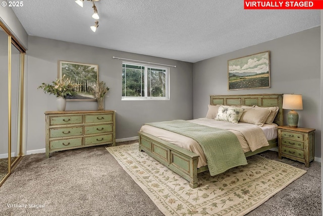 carpeted bedroom with baseboards, a textured ceiling, and a closet