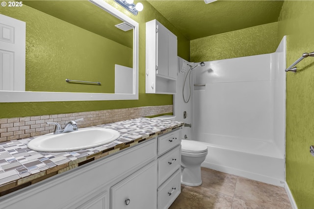 full bathroom with toilet, backsplash, shower / tub combination, vanity, and a textured wall