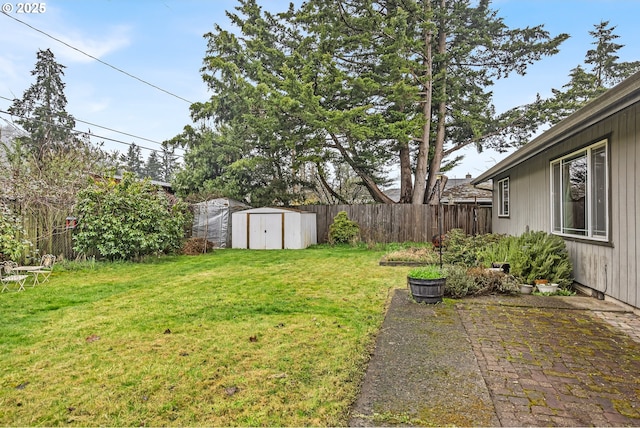 view of yard featuring an outbuilding, a storage unit, fence, and a patio area