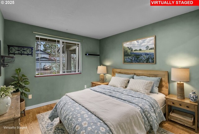 bedroom with baseboards and wood finished floors