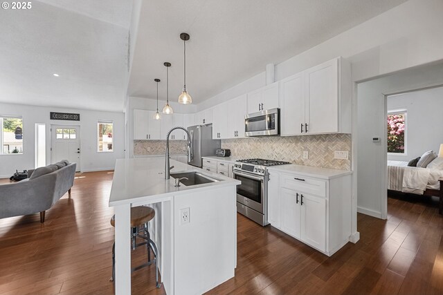 970/974 SE Roberts Ave, Gresham, OR 97080 - kitchen featuring appliances with stainless steel finishes, open floor plan, a sink, backsplash, and a kitchen breakfast bar
