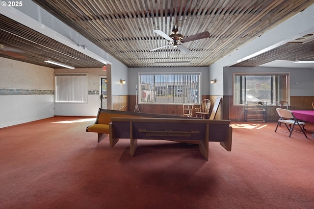 115 8th St, Winchester Bay, OR 97467 - playroom featuring a wainscoted wall, wooden walls, ceiling fan, and carpet flooring
