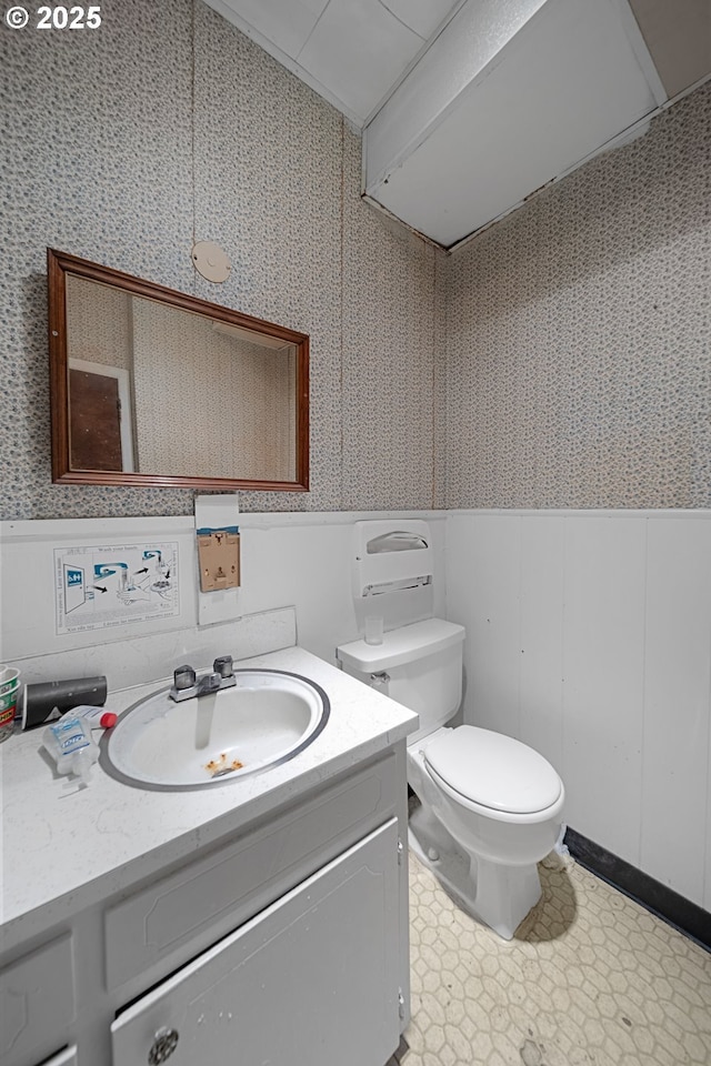 115 8th St, Winchester Bay, OR 97467 - half bath with wallpapered walls, toilet, a wainscoted wall, and vanity