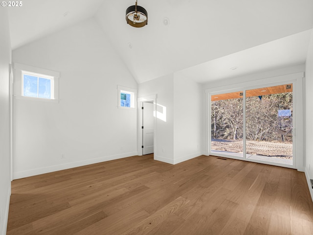 interior space with wood-type flooring and high vaulted ceiling