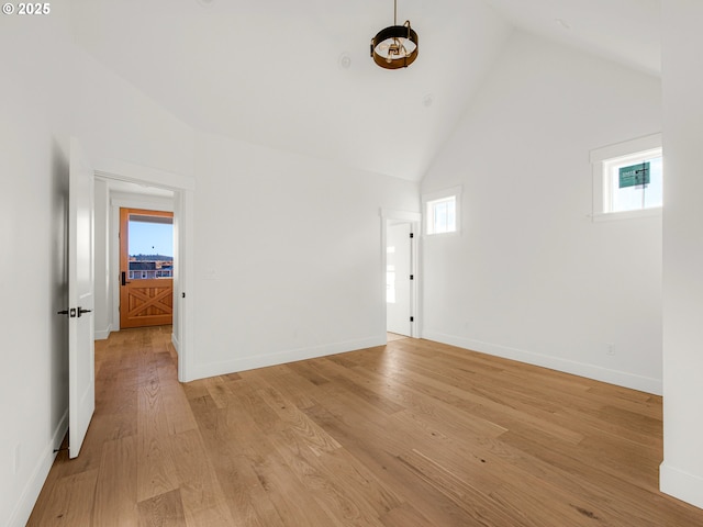 unfurnished room featuring light hardwood / wood-style floors and high vaulted ceiling